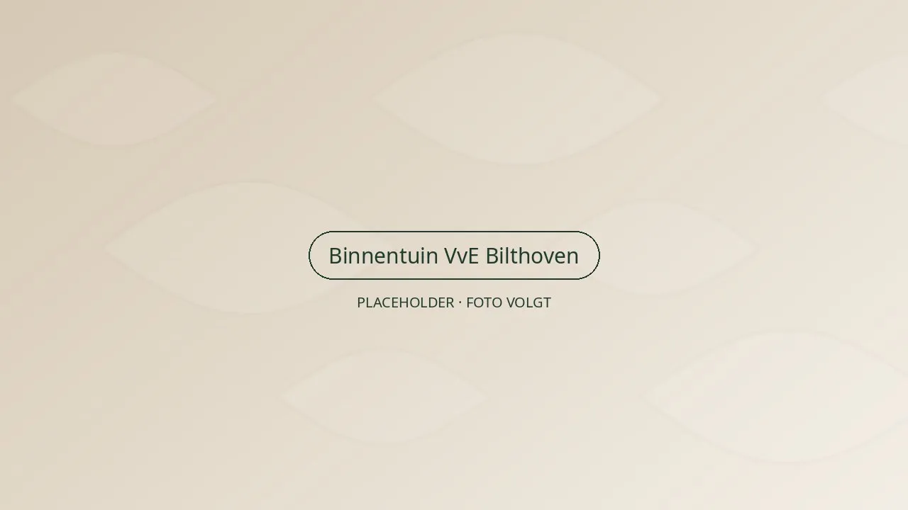 Verzorgde gemeenschappelijke binnentuin tussen appartementengebouwen in Bilthoven, met gazon, hagen en bloeiende borders